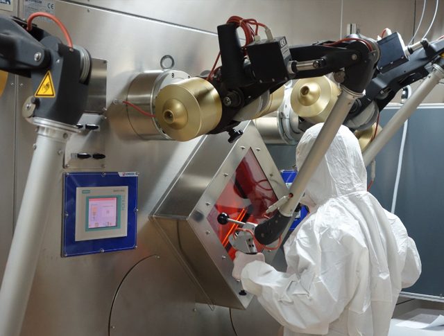 Technician in protective coveralls servicing equipment in a radiation controlled area
